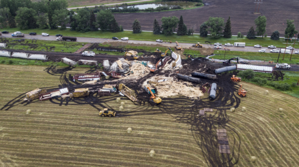 Crews work to clean up a spill after the derailment of a 20-car train carrying tar sands and lumber near Blackfalds, Alberta, Canada, on July 3, 2021. (Jeff McIntosh/The Canadian Press via AP)