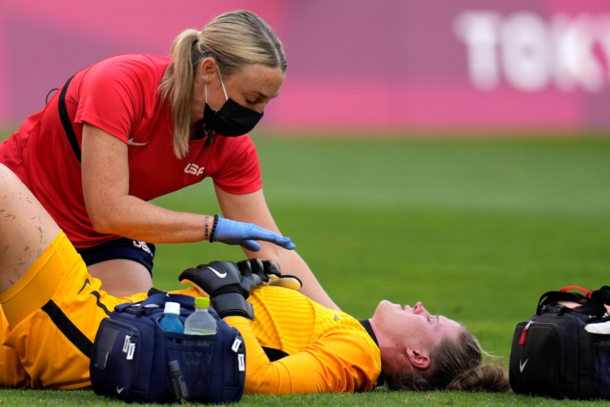 United States' goalkeeper Alyssa Naeher, below, lies on the field during a women's semifinal soccer match against Canada at the 2020 Summer Olympics, in Kashima, Japan, on Aug. 2, 2021. (Fernando Vergara/AP)