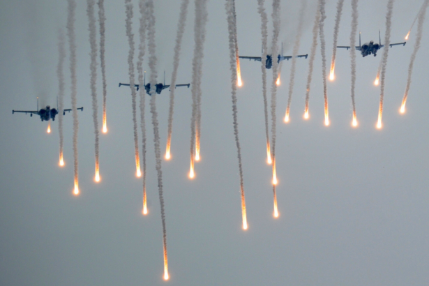 Helicopters fly above servicemen running to positions during the joint Russian–Belarusian military exercises Zapad-2017 (West-2017) at a training ground near the town of Borisov on Sept. 20, 2017. (Sergei Gapon/AFP via Getty Images)