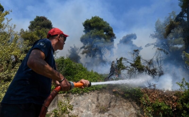 A firefighter tries to extinguish a wildfire burning near the village of Vasilika, on the island of Evia, Greece, on Aug. 8, 2021. (Alexandros Avramidis/Reuters)
