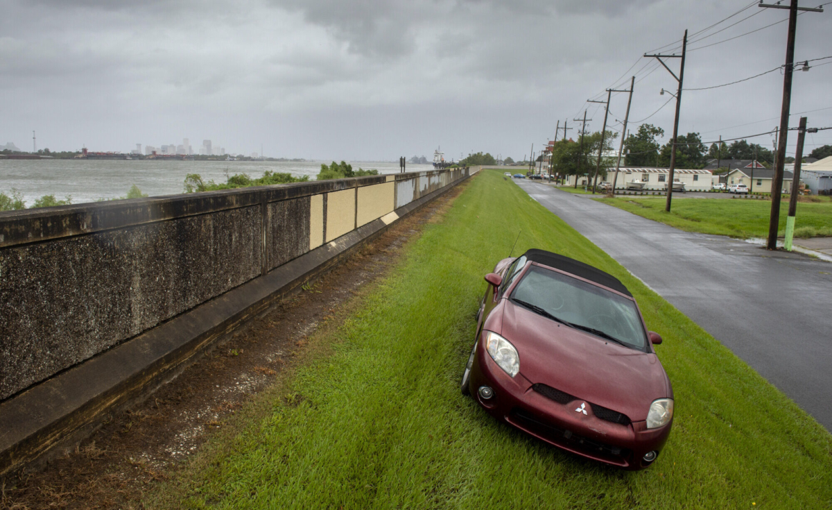 Seeking higher ground from flooding, a car is parked on the Mississippi River levee just down river from New Orleans, back left, as Hurricane Ida arrives into Louisiana on Aug. 29, 2021. (Chris Granger/The Advocate via AP)