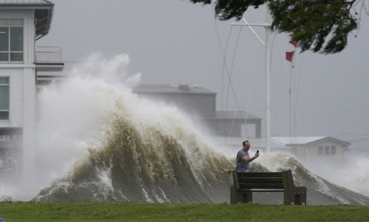 A man takes pictures of high waves along the shore of Lake Pontchartrain as Hurricane Ida nears, in New Orleans, La., on Aug. 29, 2021. (Gerald Herbert/AP Photo)