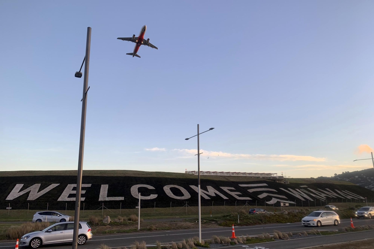 A giant sign painted near the main runway of the Wellington International Airport greets travelers returning home in Wellington, New Zealand on April 19, 2021. (Nick Perry/AP Photo)