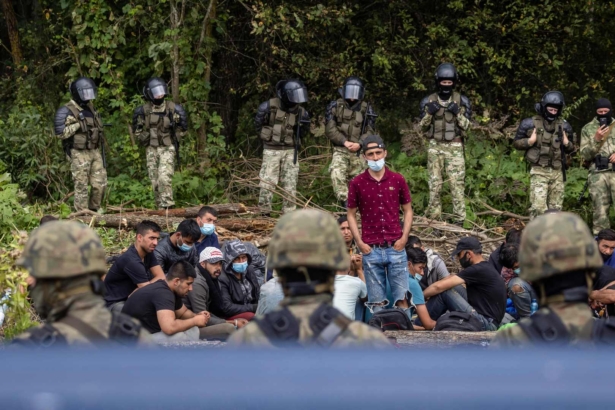 A member of a group of migrants believed to be from Afghanistan stands as he tries to confirm their will to apply for international protection in Poland to Polish volunteer lawyers, in the presence of press members and Polish Parliament deputies, in the small village of Usnarz Gorny near Bialystok, northeastern Poland, located close to the border with Belarus, on Aug. 20, 2021.(Wojtek Radwanski/AFP via Getty Images)