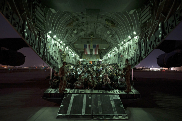 A U.S. Air Force aircrew, assigned to the 816th Expeditionary Airlift Squadron, assists qualified evacuees aboard a U.S. Air Force C-17 Globemaster III aircraft in support of the Afghanistan evacuation at Hamid Karzai International Airport, Afghanistan, on Aug. 21, 2021. (U.S. Air Force Photo by Senior Airman Taylor Crul)