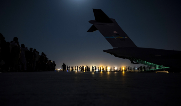 A U.S. Air Force aircrew, assigned to the 816th Expeditionary Airlift Squadron, assists qualified evacuees aboard a U.S. Air Force C-17 Globemaster III aircraft in support of the Afghanistan evacuation at Hamid Karzai International Airport, Afghanistan, on Aug. 21, 2021. (U.S. Air Force Photo by Senior Airman Taylor Crul)