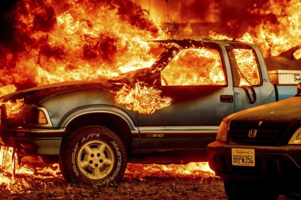 Flames from the Dixie Fire consume a pickup truck on Highway 89 south of Greenville in Plumas County, Calif., on Aug. 5, 2021. (Noah Berger/AP Photo)