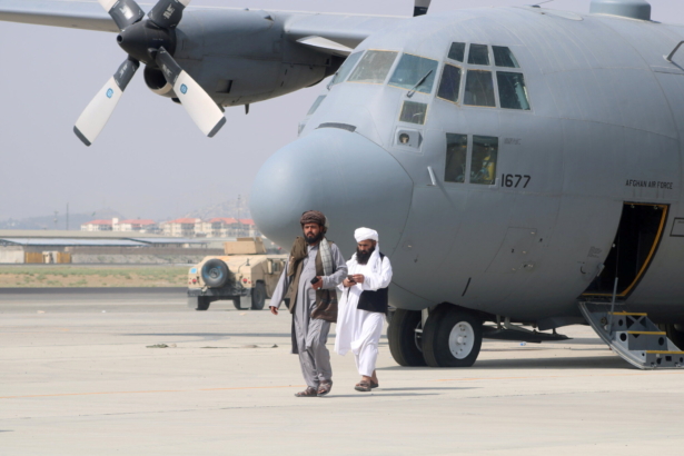 Taliban terrorists walk in front of a military airplane a day after the U.S. troop withdrawal from Hamid Karzai International Airport in Kabul, Afghanistan on Aug. 31, 2021. (Stringer/Reuters)
