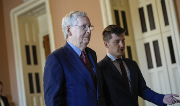 Senate Minority Leader Mitch McConnell (R-Ky.) walks with an aide as he returns to his office after speaking on the Senate floor at the U.S. Capitol in Washington on Sept. 27, 2021. (Drew Angerer/Getty Images)