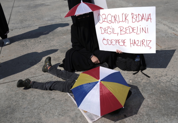 A woman holds a placard reading, "Freedom is not free. We are ready to pay for it," during a protest against official COVID-19-related mandates including vaccinations, tests, and masks, in Istanbul, Turkey, on Sept. 11, 2021. (Murad Sezer/Reuters)