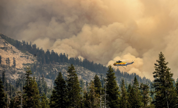 A helicopter flies over Wrights Lake while battling the Caldor Fire in Eldorado National Forest, Calif., on Wednesday, Sept. 1, 2021. (AP Photo/Noah Berger)