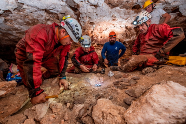 Archeologists of the National Institute of Anthropology and History (INAH) observe fragments of pottery in a cave, as part of the archeological work accompanying the construction of a controversial new tourist train, in the state of Yucatan, in this handout released on Oct. 29, 2021. (Mexico's National Institute of Anthropology and History (INAH)/Handout via Reuters)