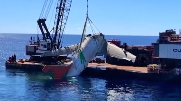 The fuselage of TransAir flight 810 is being lifted out of the water onto a ship off Honolulu, Hawaii, on Oct. 30, 2021. (National Transportation Safety Board via AP/Screenshot via NTD)