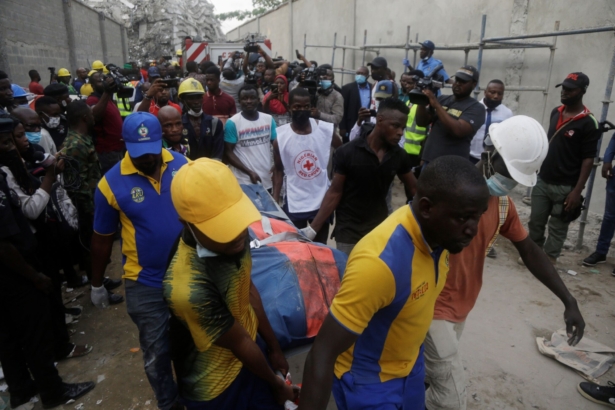Rescue workers carry a body at the site of a collapsed 21-story apartment building under construction in Lagos, Nigeria, on Nov. 1, 2021. (Sunday Alamba/AP Photo)
