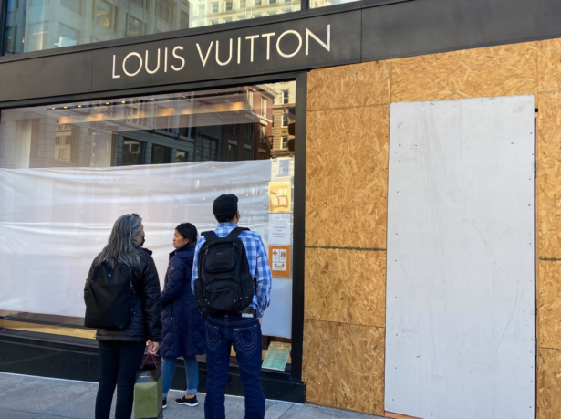 Union Square visitors look at damage to the Louis Vuitton store on Nov. 21, 2021, after looters ransacked businesses late Saturday night in San Francisco. (Danielle Echeverria/San Francisco Chronicle via AP)