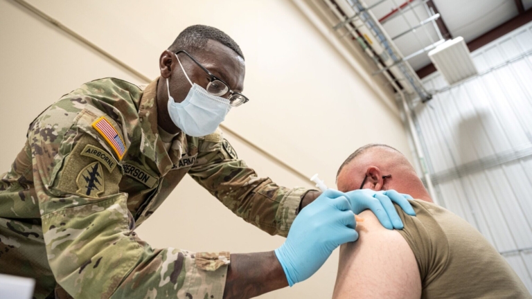 Sergeant First Class Demetrius Roberson administers a COVID-19 vaccine