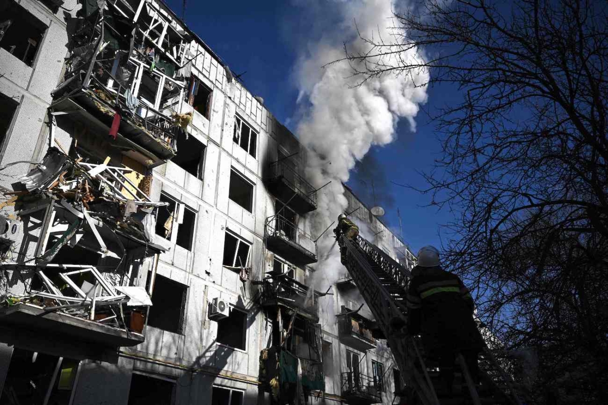 Firefighters work on a fire on a building after bombings on the eastern Ukraine town of Chuguiv on Feb. 24, 2022. (Aris Messinis/AFP via Getty Images)