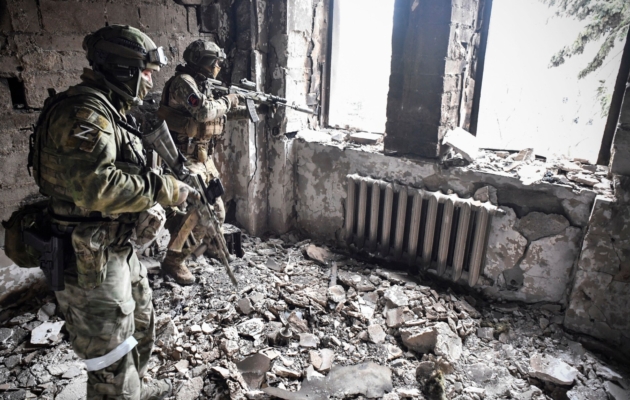 Two Russian soldiers patrol in the Mariupol drama theatre, which was bombed on March 16, in Mariupol, Ukraine, on April 12, 2022. (Alexander Nemenov/AFP via Getty Images)