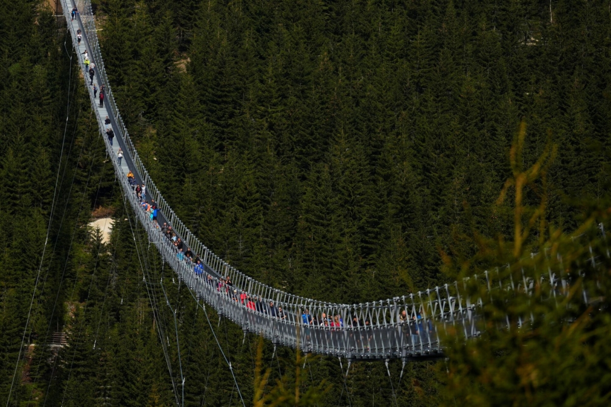 Visitors cross a suspension bridge for the pedestrians that is the longest such construction in the world shortly after its official opening at a mountain resort in Dolni Morava, Czech Republic, on May 13, 2022. (Petr David Josek/AP Photo)