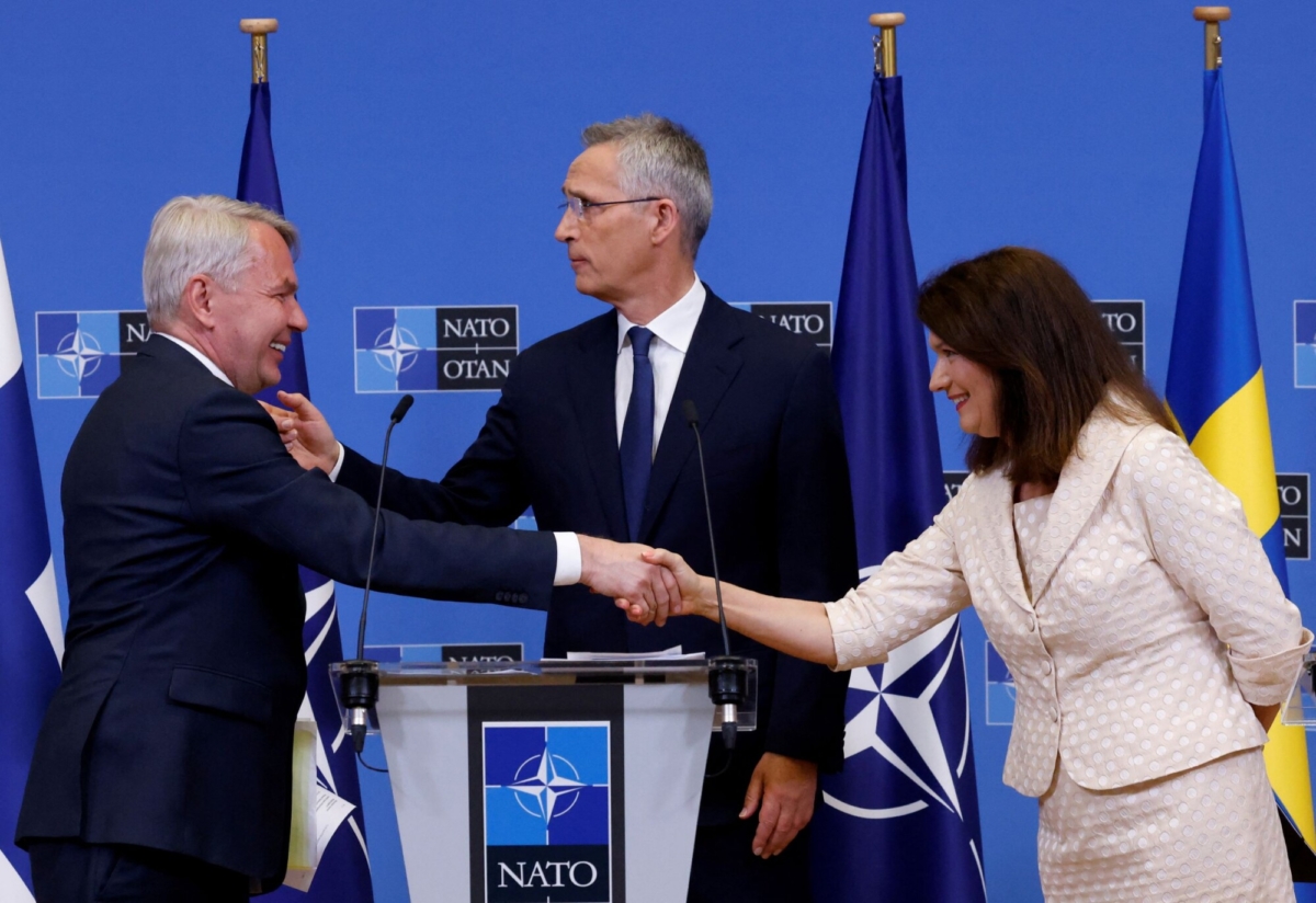 Sweden's Foreign Minister Ann Linde (R), and Finland's Foreign Minister Pekka Haavisto (L) shake hands during a news conference with NATO Secretary General Jens Stoltenberg, after signing their countries' accession protocols at the alliance's headquarters in Brussels on July 5, 2022. (Yves Herman/Reuters)