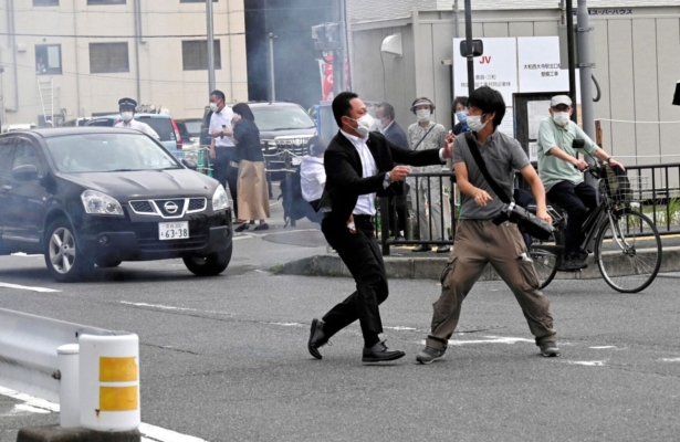 A police officer detains a man, believed to have shot former Japanese Prime Minister Shinzo Abe, in Nara, western Japan, on July 8, 2022. (The Asahi Shimbun/via Reuters)
