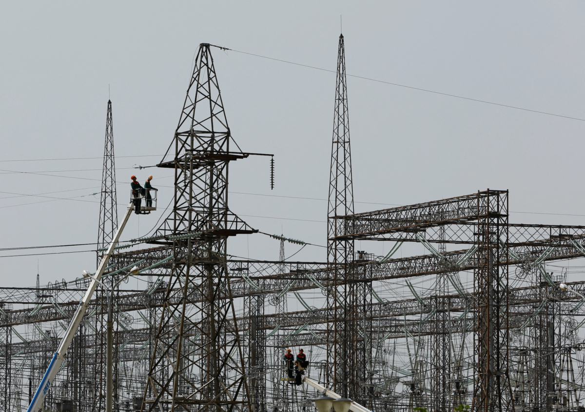 Employees work on electricity networks near the Zaporizhzhia Nuclear Power Plant outside the Russian-controlled city of Enerhodar in Zaporizhzhia region, Ukraine, on Aug. 22, 2022. (Alexander Ermochenko/Reuters)