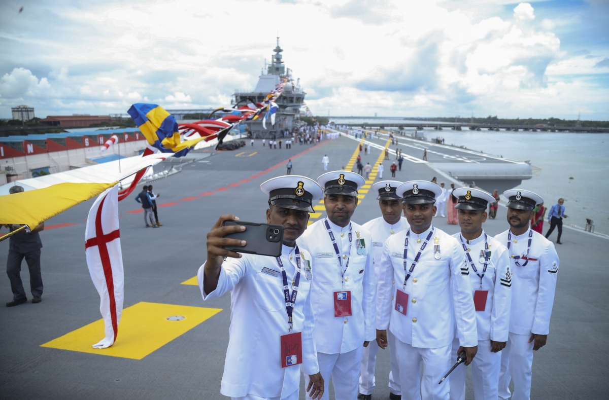 Navy sailors pose for a selfie on the deck of India's first home-built aircraft carrier INS Vikrant, after it was commissioned in Kochi, India, on Sept. 2, 2022. (Prakash Elamakkara/AP Photo)
