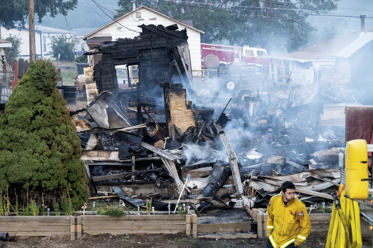 A firefighter passes a home destroyed by the Mill Fire in Weed, Calif., on Sept. 3, 2022. (Noah Berger/AP Photo)
