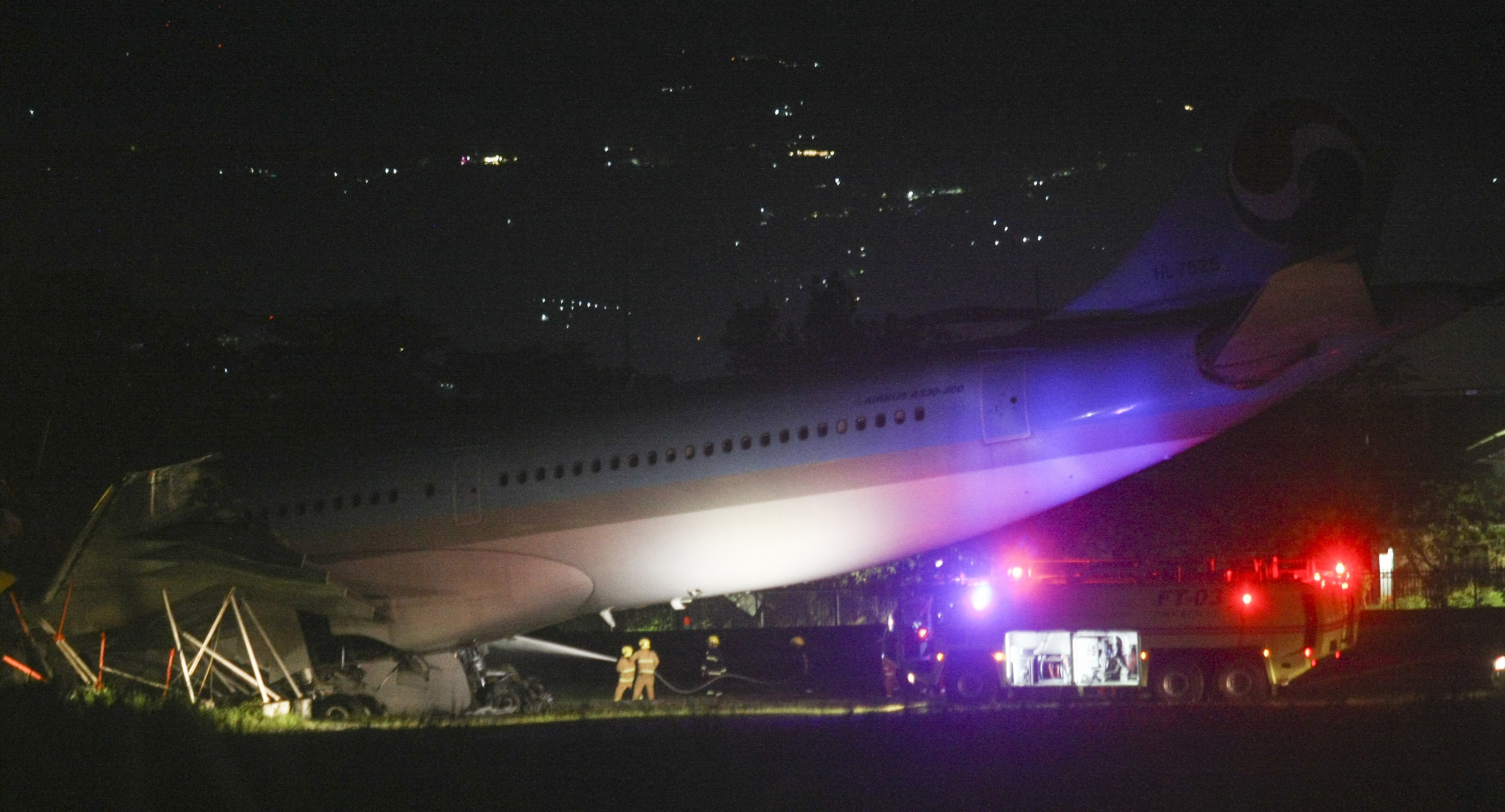 Firefighters train their hoses on a Korean Air Lines Co. plane after it overshot the runway at the Mactan-Cebu International Airport in Cebu, central Philippines, early Monday Oct. 24, 2022. (AP Photo/Juan Carlo De Vela)