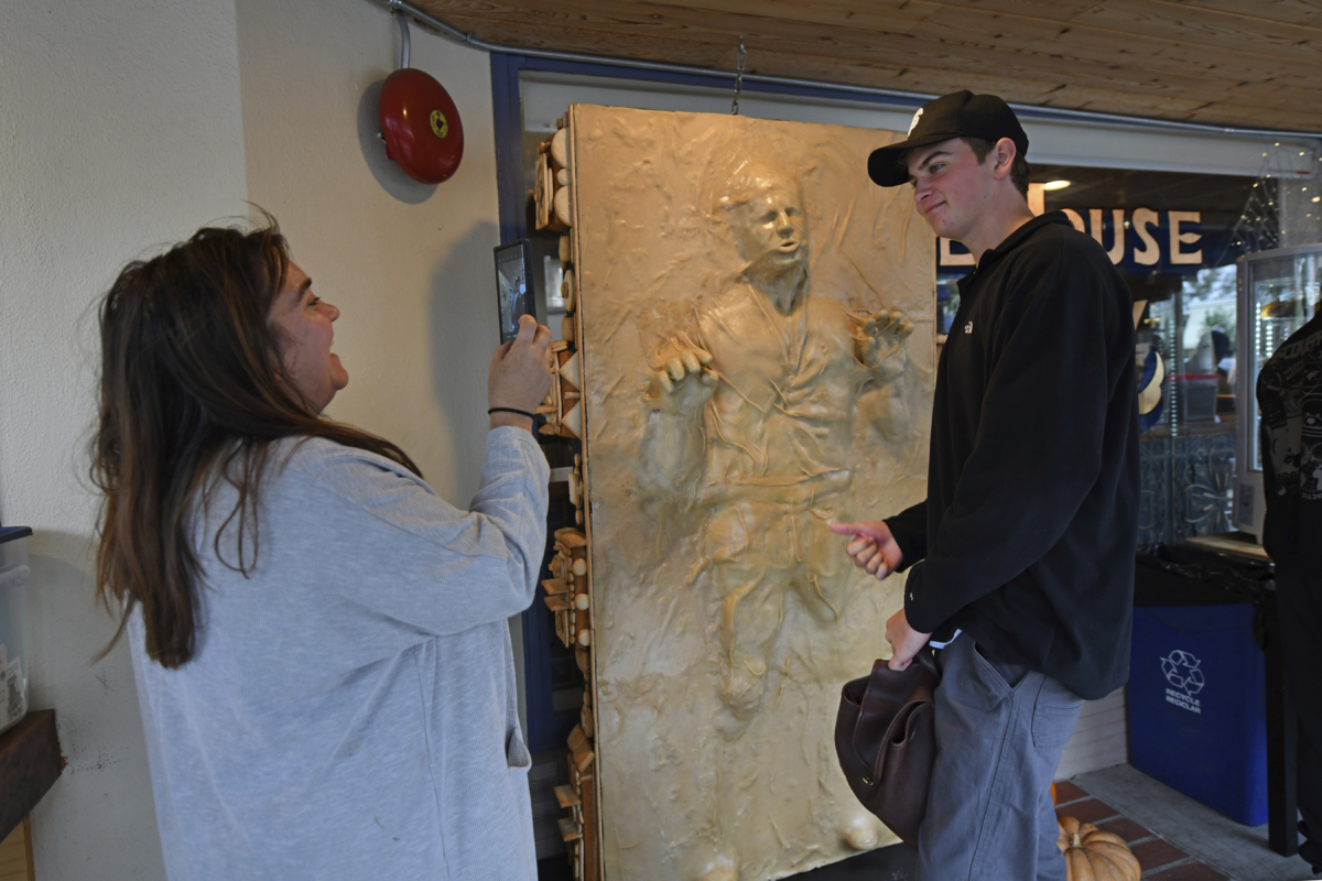 Michelle Heberling takes a photograph of her son Wesley Heberling with a sculpture of "Star Wars" character Han Solo frozen in carbonite made entirely of bread while at the One House Bakery in Benicia, Calif., on Oct. 16, 2022. (Jose Carlos Fajardo/Bay Area News Group via AP)