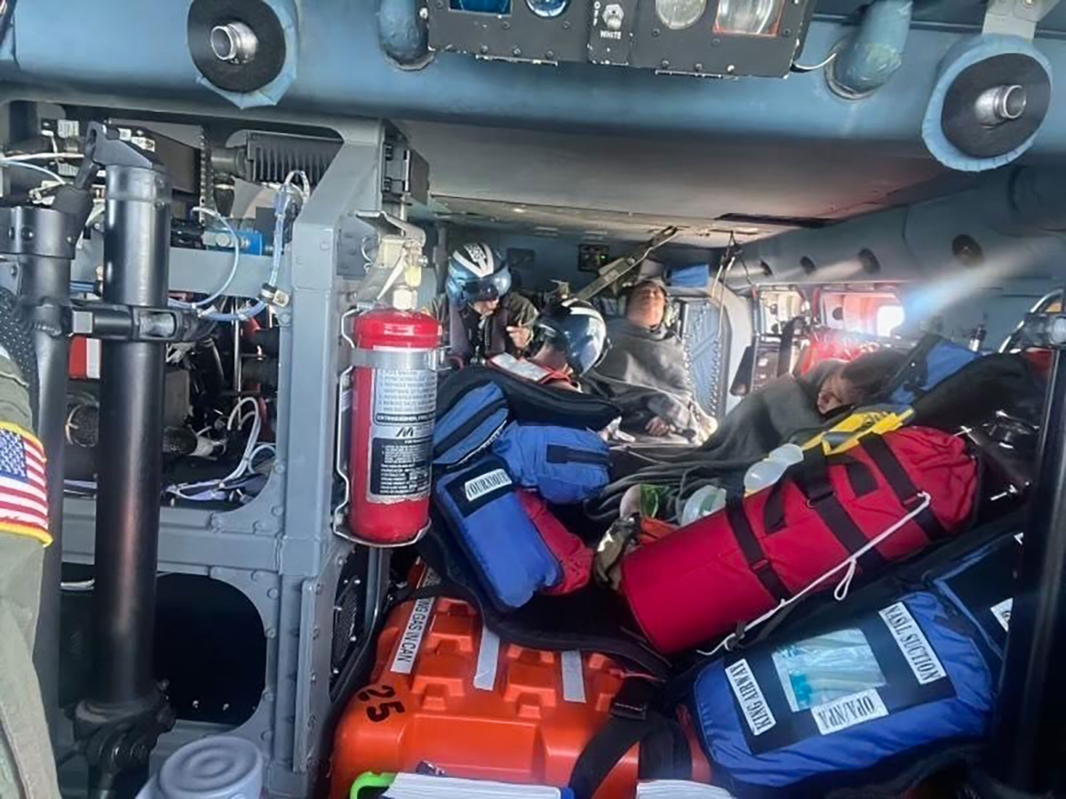 A Coast Guard Air Station New Orleans MH-60 Jayhawk aircrew treats three rescued boaters for injuries Sunday, approximately 25 miles offshore from Empire, La., on Oct. 9, 2022. (Coast Guard Air Station New Orleans)
