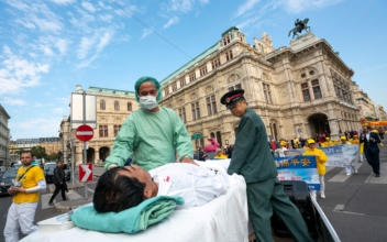 Falun Gong practitioners in Vienna, Austria, stage a demonstration of organ harvesting of imprisoned practitioners in China during a protest against the importing of human organs from China to Austria, on Oct. 1, 2018. (Joe Klamar/AFP via Getty Images)