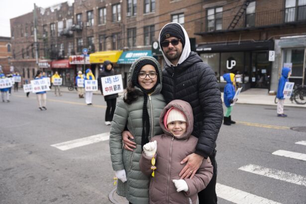 Miguel Garcia and his family watch Falun Gong practitioners march in a parade