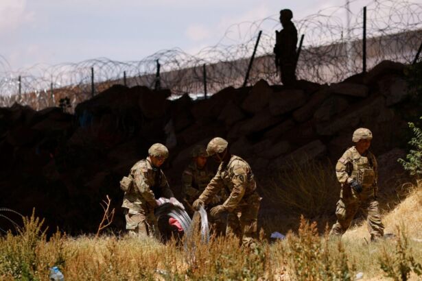 Members Of The Texas Army National Guard Extend Razor Wire To Inhibit Migrants From Crossing As Seen From Ciudad Juarez