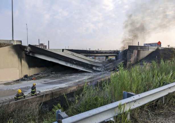 Firefighters stand near the collapsed part of I-95
