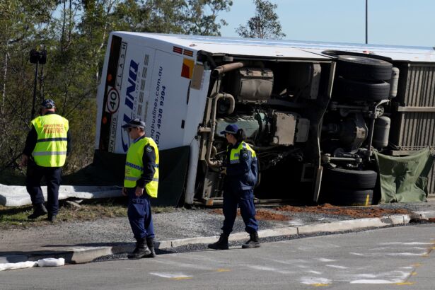 Police inspect a bus on its side near the town of Greta following a crash in the Hunter Valley, north of Sydney on June 12, 2023. (Mark Baker/AP Photo)