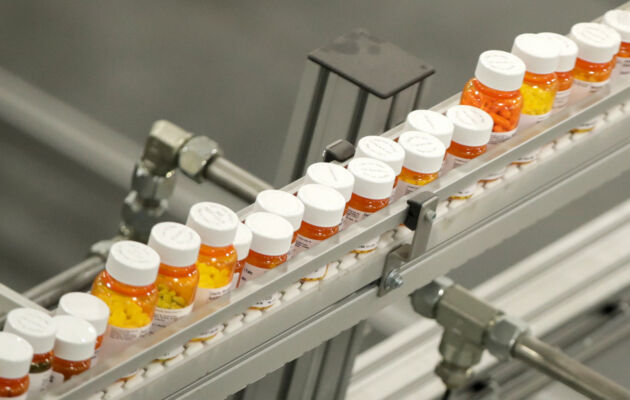 Bottles of medicine ride on a belt at a mail-in pharmacy warehouse in Florence, N.J., on July 10, 2018. (Julio Cortez/AP Photo)