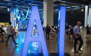 People walk past an AI sign at the All In artificial intelligence conference in Montreal on Sept. 28, 2023. (The Canadian Press/Ryan Remiorz)