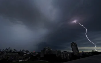 Lightning strikes in the distance as a thunderstorm passes over downtown Kansas City, Mo., on July 30, 2023. (Charlie Riedel/AP Photo)