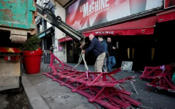 The broken sails of the landmark red windmill atop the Moulin Rouge, Paris' most famous cabaret club, are taken away after they fell off during the night in Paris on April 25, 2024. (Benoit Tessier/Reuters)