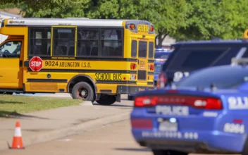 Police vehicles and school buses are prepared to escort students to be reunited with their families at Arlington Bowie High School after the school was placed on a lockdown due to a suspected shooting outside the school building in Arlington, Texas, on April 24, 2024. (Gareth Patterson/AP Photo)