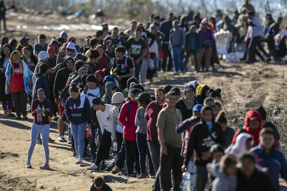 More than 1,000 migrants wait in line