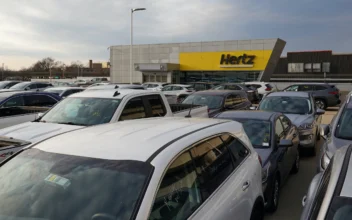 Cars are parked near a Hertz car rental signage at John F. Kennedy International Airport in New York, on March 30, 2022. (Andrew Kelly/Reuters)