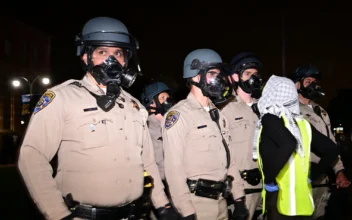 U.S. Police officers face a protester as they stand guard after clashes erupted on the campus of the University of California Los Angeles (UCLA), in Los Angeles on May 1, 2024. (Frederic J. Brown/AFP via Getty Images)