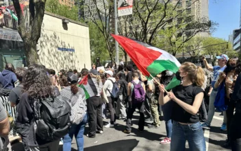 Riley Kerr waves the Palestinian flag at Fordham University rally on May 1, 2024. (Juliette Fairley/The Epoch Times)