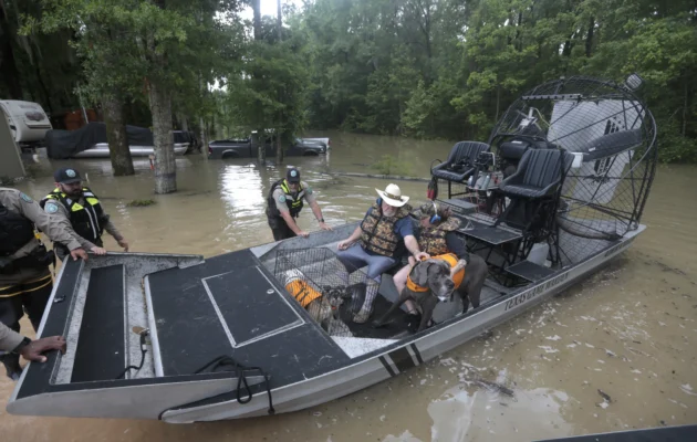 Texas Parks & Wildlife Department game wardens use a boat to rescue residents from floodwaters in Liberty County, Texas, on May 4, 2024. (Lekan Oyekanmi/AP Photo)