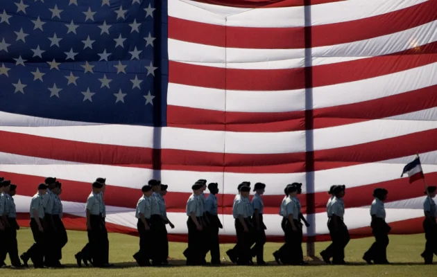 Troops march past a large American flag as they graduate from Basic Combat Training at Fort Jackson, S.C., on Nov. 2, 2007. (Paul J. Richards/AFP via Getty Images)