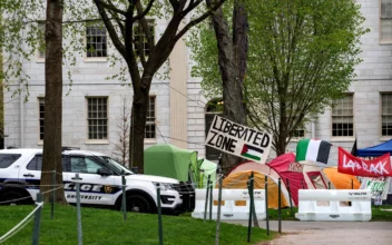 A police cruiser sits by tents and signs that fill Harvard Yard by the John Harvard statue in the Pro-Palestinian encampment at Harvard University in Cambridge, Mass., on May 5, 2024. (Joseph Prezioso/AFP via Getty Images)