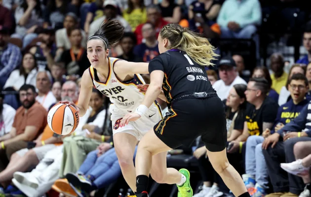 Caitlin Clark #22 of the Indiana Fever controls the ball as Rachel Banham #1 of the Connecticut Sun defends at Mohegan Sun Arena in Uncasville, Conn., on May 14, 2024. (Elsa/Getty Images)