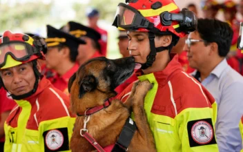A dog named Ares licks its handler during a retirement ceremony for firefighter work dogs in Quito, Ecuador, on May 20, 2024. (Dolores Ochoa/AP Photo)